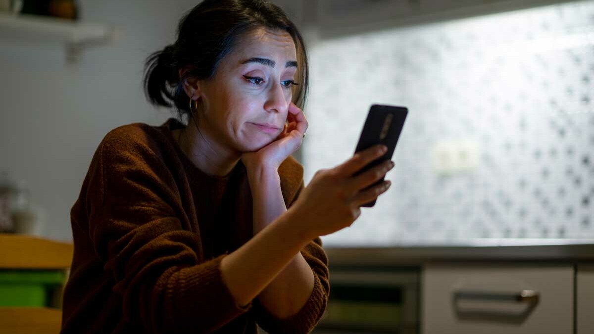 photo of woman looking at phone in frustration